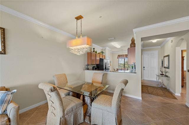 17921 Bonita National Blvd, #244, Bonita Springs, FL 34135 Dining area featuring a contemporary chandelier, tile flooring, and crown molding