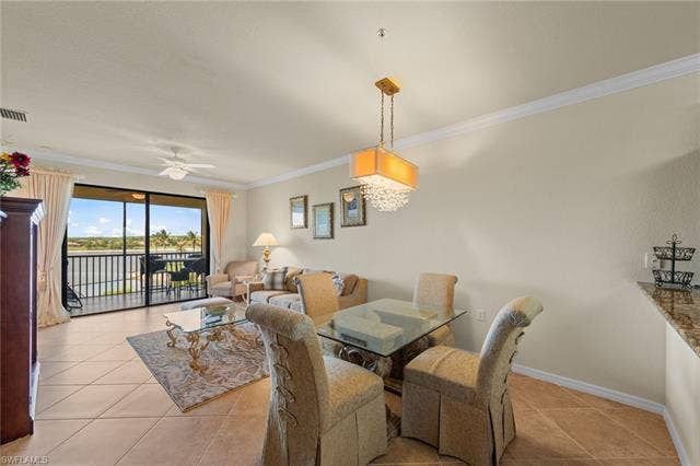 17921 Bonita National Blvd, #244, Bonita Springs, FL 34135 Open-concept living and dining area featuring tile flooring, crown molding, and a chandelier with crystal accents