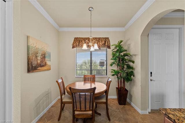17921 Bonita National Blvd, #244, Bonita Springs, FL 34135 Dining space featuring tile flooring, crown molding, a window with horizontal blinds, and an arched entry