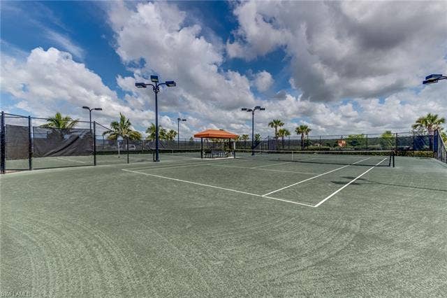 17921 Bonita National Blvd, #244, Bonita Springs, FL 34135 Tennis courts featuring a hard surface, surrounding perimeter fencing, and integrated lighting