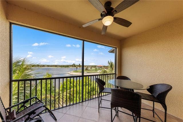 17921 Bonita National Blvd, #244, Bonita Springs, FL 34135 Screened balcony featuring a ceiling fan with integrated lighting, textured walls, and tile flooring
