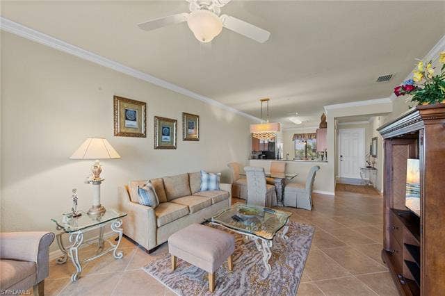 17921 Bonita National Blvd, #244, Bonita Springs, FL 34135 Open-concept living space featuring neutral tone wall paint, crown molding, and diagonal tile flooring