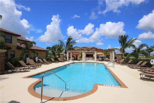 17921 Bonita National Blvd, #244, Bonita Springs, FL 34135 Rectangular swimming pool with integrated spa featuring a brick coping and light-colored decking