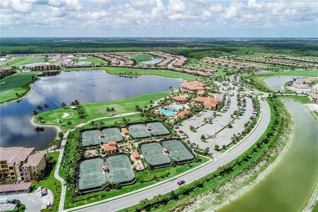 17921 Bonita National Blvd, #244, Bonita Springs, FL 34135 Expansive golf course community featuring multiple tennis courts, a swimming pool, and a large lake surrounded by residential properties and green spaces