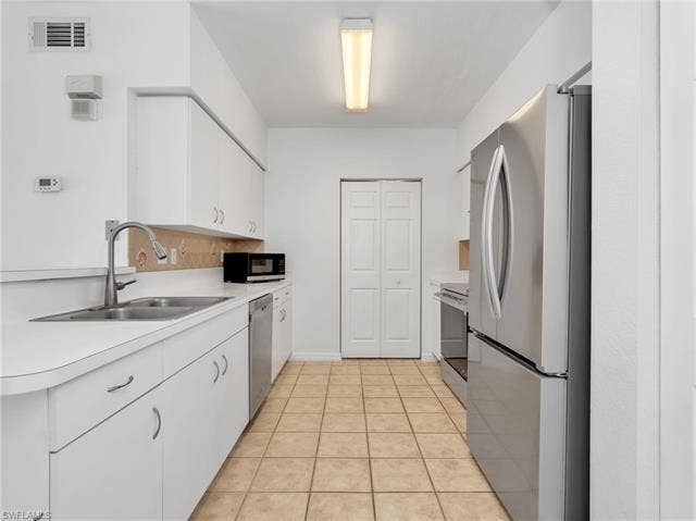 27087 Matheson Ave, #101, Bonita Springs, FL 34135 Kitchen with Tile Flooring, White Cabinetry, Stainless Steel Appliances Including new LG French Door Refrigerator & Range, Newer Whirlpool Dishwasher, Tile Backsplash & Pantry