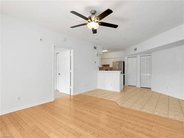 27087 Matheson Ave, #101, Bonita Springs, FL 34135 Kitchen with Tile Flooring, White Cabinetry, Stainless Steel Appliances, Tile Backsplash & Pantry - Door To Primary