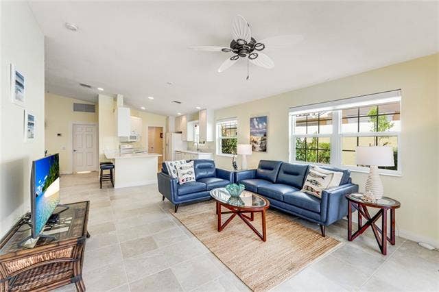28179 Islet Trl, Bonita Springs, FL 34135 Spacious living area featuring high vaulted ceilings, large windows with white blinds, and light-toned tile flooring