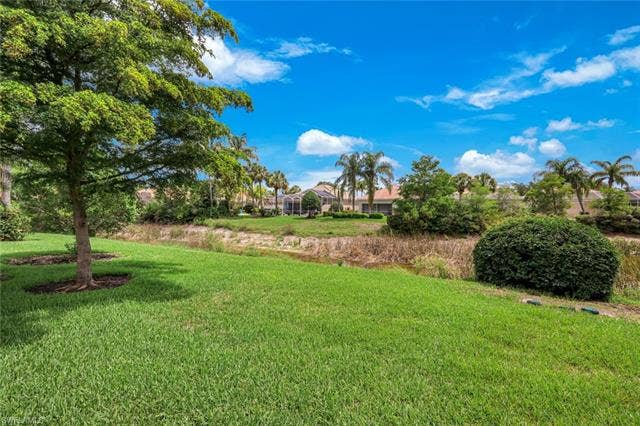 28179 Islet Trl, Bonita Springs, FL 34135 Expansive green lawn with mature trees and landscaping