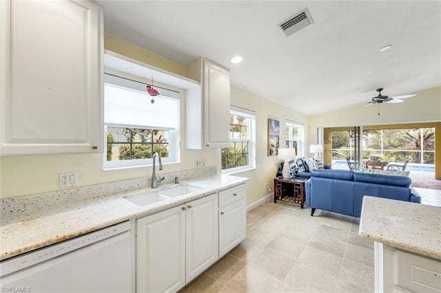 28179 Islet Trl, Bonita Springs, FL 34135 Kitchen sink area with light-toned countertops, white cabinetry, and a window overlooking exterior greenery