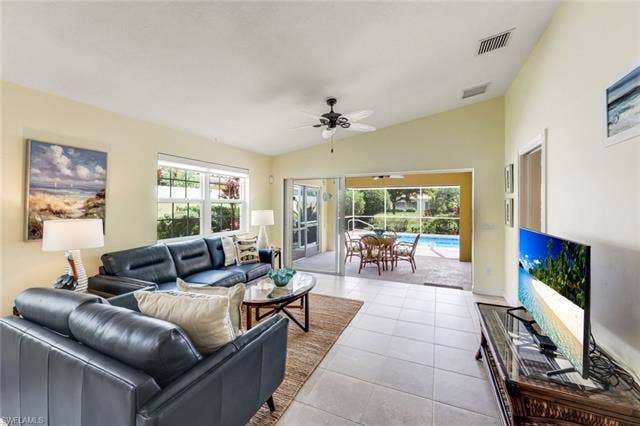 28179 Islet Trl, Bonita Springs, FL 34135 Living space featuring vaulted ceilings, tile flooring, and large windows