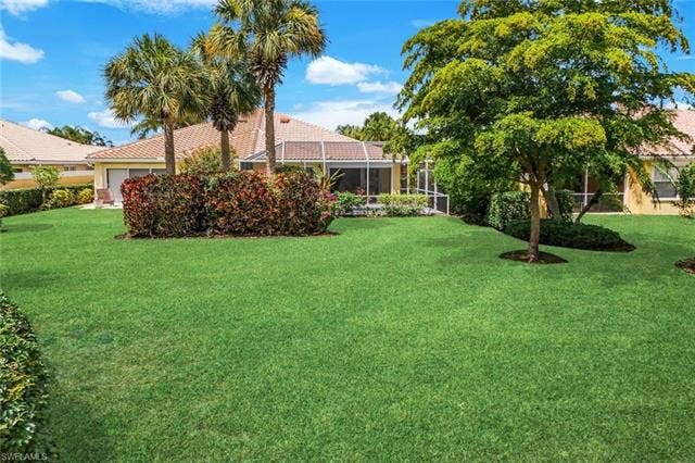 28179 Islet Trl, Bonita Springs, FL 34135 Expansive green lawn with mature trees and tropical landscaping