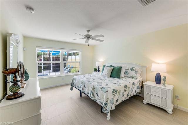 28179 Islet Trl, Bonita Springs, FL 34135 Spacious room featuring light-toned flooring, a ceiling fan, and large windows with exterior visibility