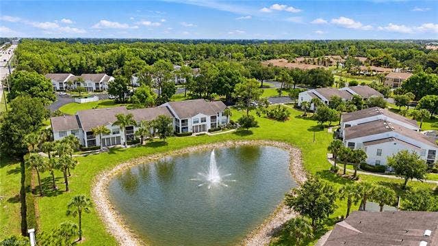132 Santa Clara Dr, #10, Naples, FL 34104 Lush landscaping surrounds a reflective pond with a central fountain feature