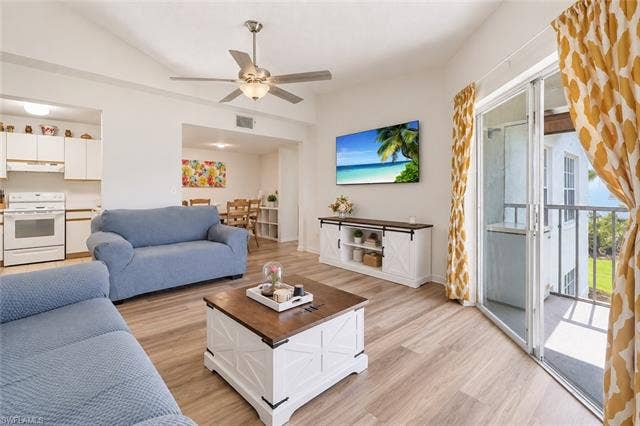 132 Santa Clara Dr, #10, Naples, FL 34104 Light wood-finish flooring, a ceiling fan with integrated lighting, and a sliding glass door leading to an outdoor balcony