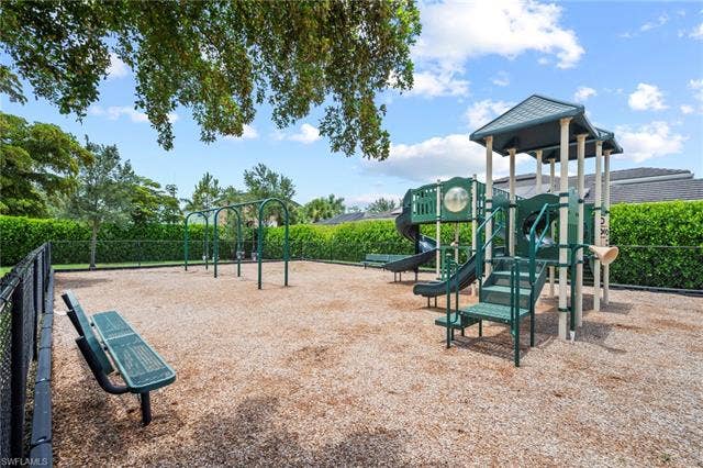 16112 Bonita Landing Cir, Bonita Springs, FL 34135 Outdoor recreational area featuring a playground structure with multiple slides and climbing elements, a swing set, and two green metal benches