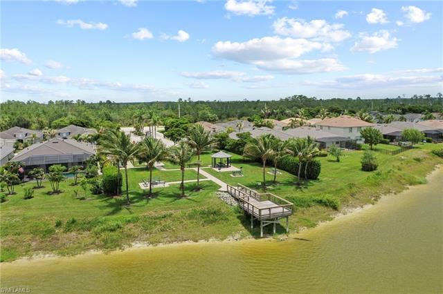 16112 Bonita Landing Cir, Bonita Springs, FL 34135 Waterfront community with a private dock, expansive green spaces, mature palm trees, and a shaded gazebo