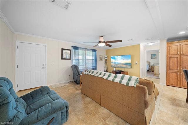 27472 Rue Viauv Ave, Bonita Springs, FL 34135 Living area featuring tile flooring, a ceiling fan with integrated lighting, and a prominent accent wall