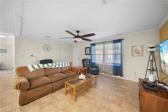 27472 Rue Viauv Ave, Bonita Springs, FL 34135 Spacious living area featuring tile flooring, neutral wall tones, and crown molding