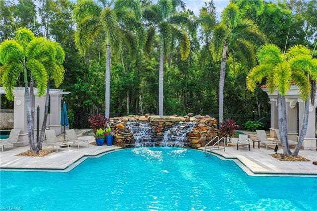 23461 Alamanda Dr, #206, Estero, FL 34135 Resort-style pool with a stone waterfall feature and integrated steps