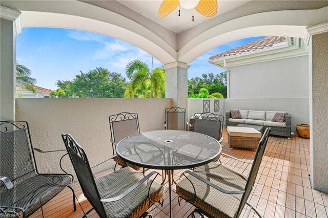 23461 Alamanda Dr, #206, Estero, FL 34135 Spacious outdoor patio featuring wood-finish flooring, a ceiling fan, and arched architectural details