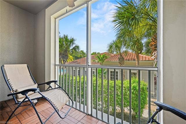 23461 Alamanda Dr, #206, Estero, FL 34135 Screened patio featuring wood-look tile flooring and a ceiling fan