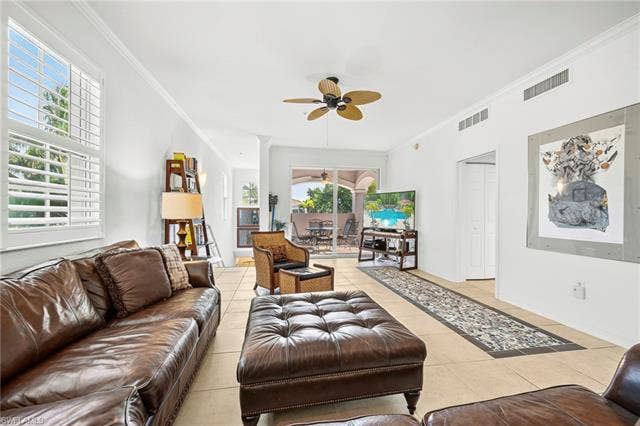 23461 Alamanda Dr, #206, Estero, FL 34135 Spacious living area featuring tile flooring, crown molding, and a ceiling fan