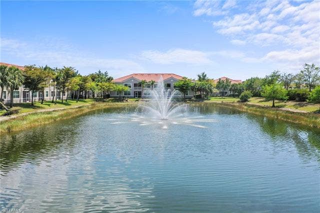 23461 Alamanda Dr, #206, Estero, FL 34135 Expansive water feature with a central fountain, bordered by green landscaping and palm trees