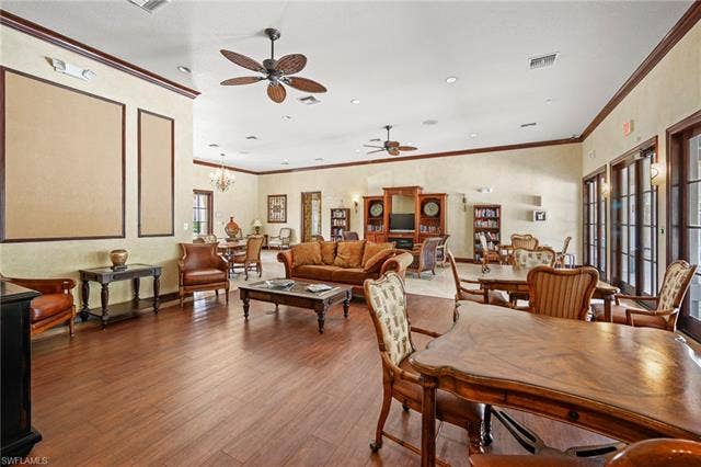 23461 Alamanda Dr, #206, Estero, FL 34135 Spacious common area featuring wood-finish flooring, crown molding, multiple ceiling fans, and recessed lighting