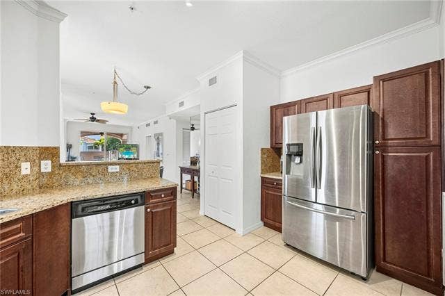 23461 Alamanda Dr, #206, Estero, FL 34135 Kitchen featuring granite countertops, wood cabinetry, stainless steel appliances, and tile flooring