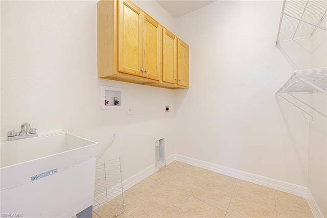 10310 Carolina Willow Dr, Fort Myers, FL 33913 Utility room with overhead cabinetry, a laundry basin, and wall-mounted shelving