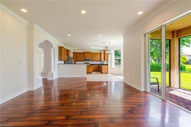 10310 Carolina Willow Dr, Fort Myers, FL 33913 Hardwood-finish flooring, recessed lighting, arched entryway, sliding glass doors, and a screened patio