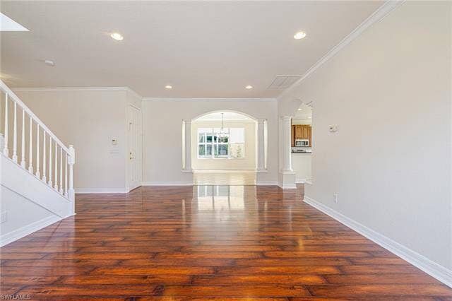 10310 Carolina Willow Dr, Fort Myers, FL 33913 Wood-finish flooring throughout, white crown molding, recessed lighting, and arched doorways with decorative columns