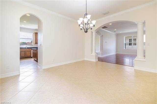 10310 Carolina Willow Dr, Fort Myers, FL 33913 Tile flooring with diagonal pattern, arched entryways, crown molding, and a multi-arm chandelier