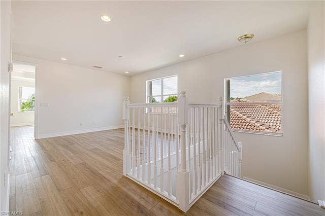 10310 Carolina Willow Dr, Fort Myers, FL 33913 Wood-finish flooring throughout, recessed lighting, white painted balusters and newel posts, and multiple windows
