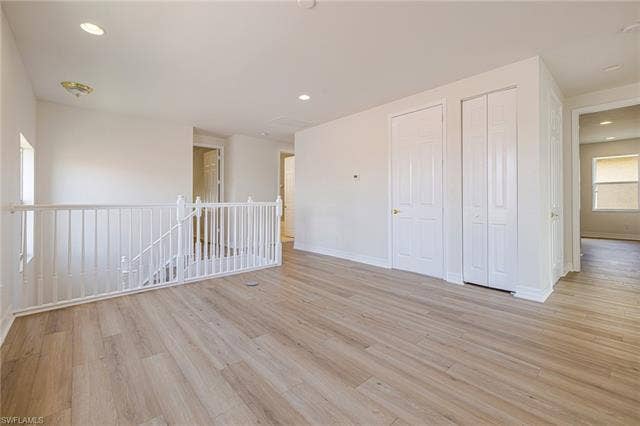 10310 Carolina Willow Dr, Fort Myers, FL 33913 Spacious room featuring wood-finish flooring, white walls, recessed lighting, and a white stair railing