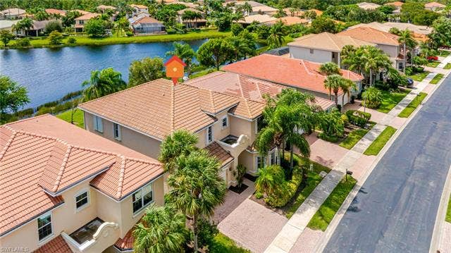 10310 Carolina Willow Dr, Fort Myers, FL 33913 Two-story residence featuring a tile roof, paved driveway, and mature landscaping