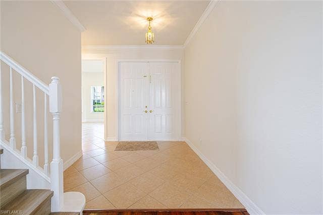 10310 Carolina Willow Dr, Fort Myers, FL 33913 Double entry doors with gold-tone hardware, tile flooring, and wood-finish stair treads
