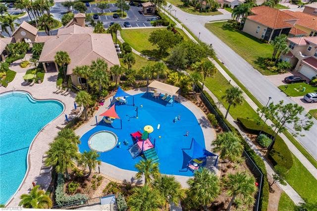 10310 Carolina Willow Dr, Fort Myers, FL 33913 Community amenities featuring a resort-style swimming pool, a splash pad with water features, and an adjacent clubhouse