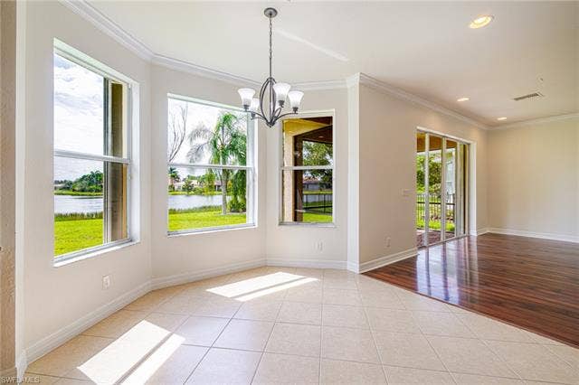 10310 Carolina Willow Dr, Fort Myers, FL 33913 Bright, light-filled sunroom with curved wall of large double-hung windows, polished tile flooring, and pendant lighting