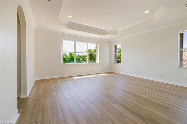 10310 Carolina Willow Dr, Fort Myers, FL 33913 Recessed lighting, wood-finish flooring, arched entryway, tray ceiling, and multiple windows
