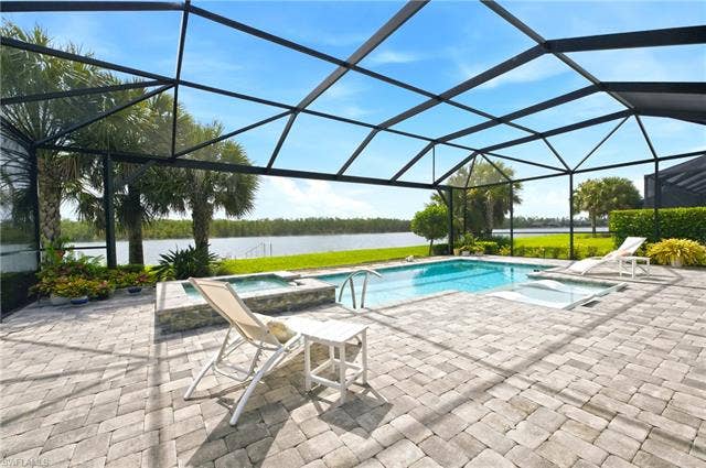 19125 Aqua Shore Dr, Estero, FL 33913 Screened outdoor living area featuring salt-water pool, integrated spa, and expansive paver patio