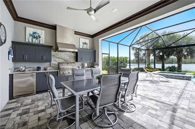 19125 Aqua Shore Dr, Estero, FL 33913 Screened outdoor living area featuring a built-in kitchen with stainless steel appliances