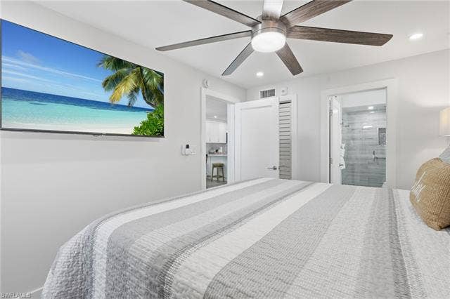 8300 Estero Blvd, #104, Fort Myers Beach, FL 33931 Recessed lighting, ceiling fan with integrated light, and a wall-mounted flat-screen display - Virtually Edited Image