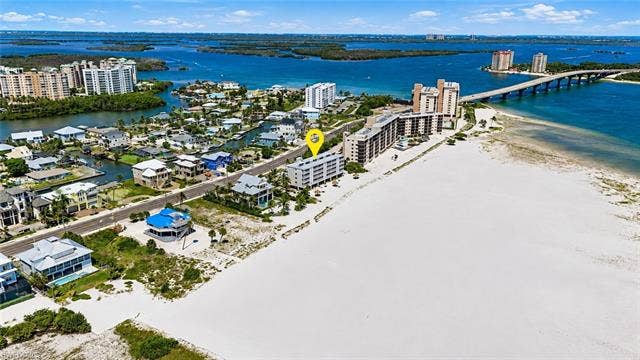 8300 Estero Blvd, #104, Fort Myers Beach, FL 33931 White sand beachfront, waterfront properties, water access, nearby bridge, high-rise architecture - Virtually Edited Image