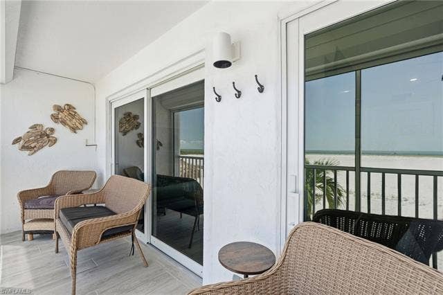 8300 Estero Blvd, #104, Fort Myers Beach, FL 33931 Screened balcony with white sand beach and ocean scenery - Virtually Edited Image