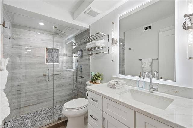 8300 Estero Blvd, #104, Fort Myers Beach, FL 33931 Glass-enclosed shower with large-format tile and pebble-finish floor - Virtually Edited Image
