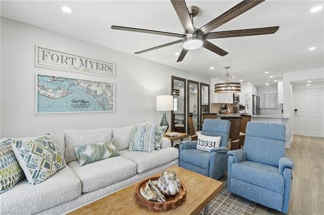 8300 Estero Blvd, #104, Fort Myers Beach, FL 33931 Recessed ceiling lighting, a contemporary ceiling fan, and wood-finish flooring enhance the living space - Virtually Edited Image