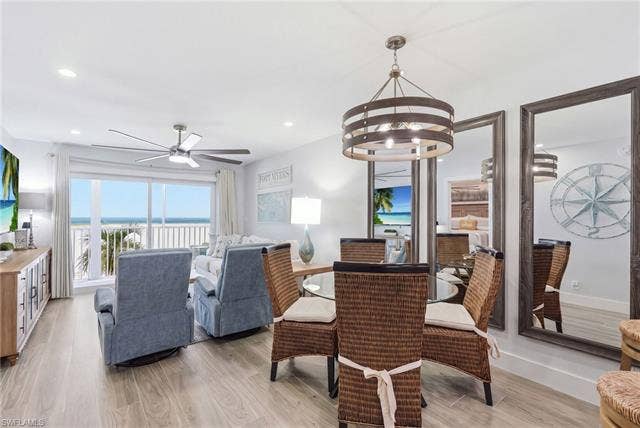 8300 Estero Blvd, #104, Fort Myers Beach, FL 33931 Sliding glass doors opening to a balcony, wood-finish flooring, recessed lighting, and a contemporary ceiling fan - Virtually Edited Image