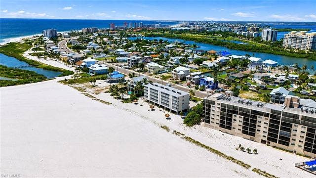8300 Estero Blvd, #104, Fort Myers Beach, FL 33931 Coastal community with beachfront properties, waterfront channels, and urban development - Virtually Edited Image