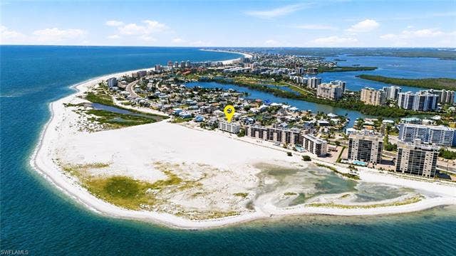 8300 Estero Blvd, #104, Fort Myers Beach, FL 33931 Coastal setting with beachfront access, surrounded by water features and established residential areas - Virtually Edited Image